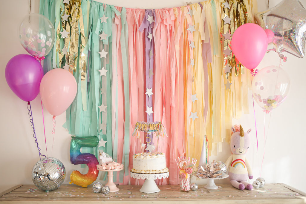 unicorn birthday party backdrop and balloons